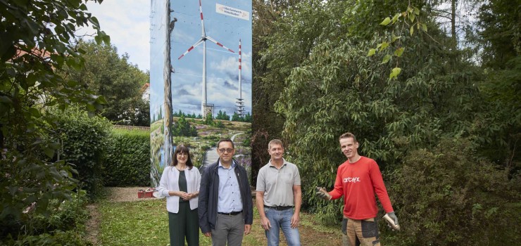 Anthea Götz vom E-Werk Mittelbaden, Oberbürgermeister Klaus Muttach und Thomas Koch vom Überlandwerk Mittelbaden beim Vor-Ort-Termin Im Walde in Oberachern mit Markus Ronge, dem professionellen Fassadengestalter und Künstlerischen Leiter bei artefx.